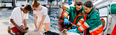 People performing CPR beside an ambulance